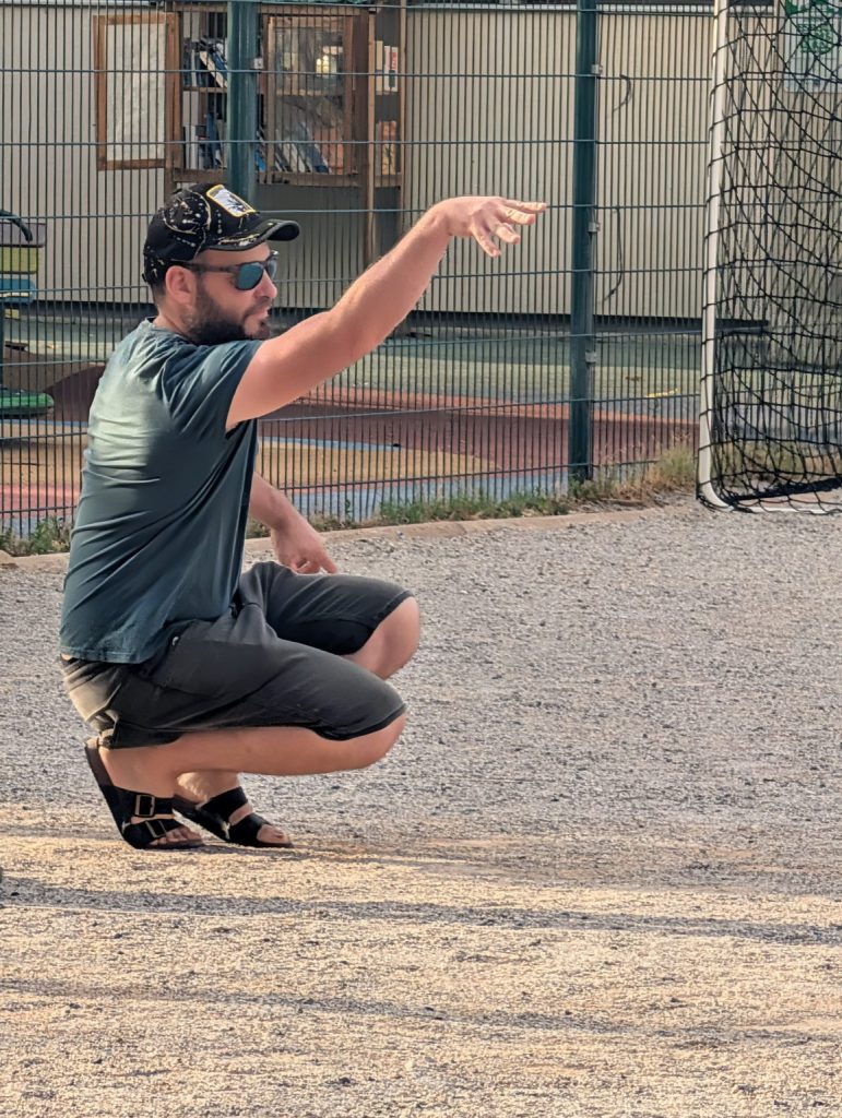 Adrien Patouillet, en tee-shirt vert et casquette, accroupi après son lancer.