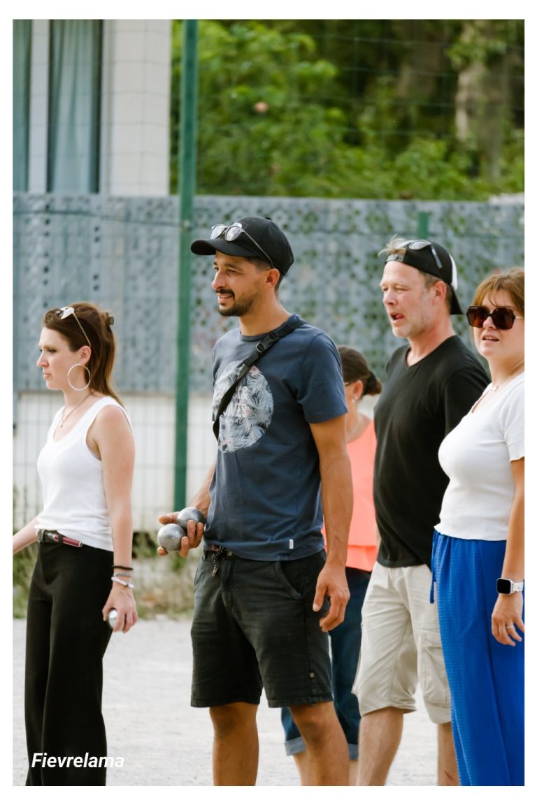 Un groupe de membres observe la partie, certains avec leurs boules à la main.