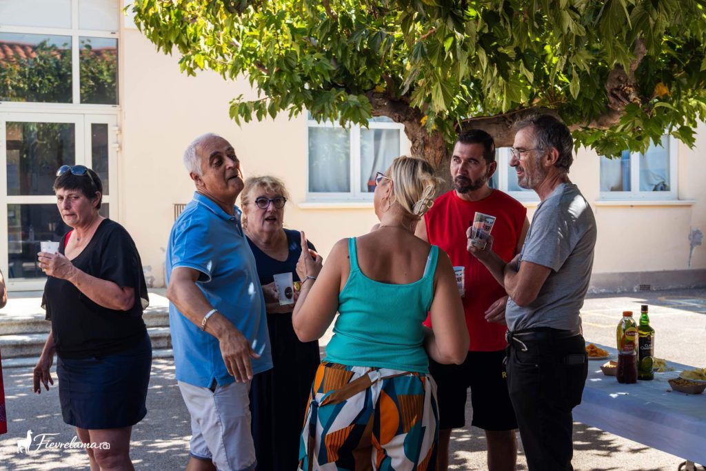 Membres du club de pétanque de Néfiach qui discutent à l’apéritif sous un platane