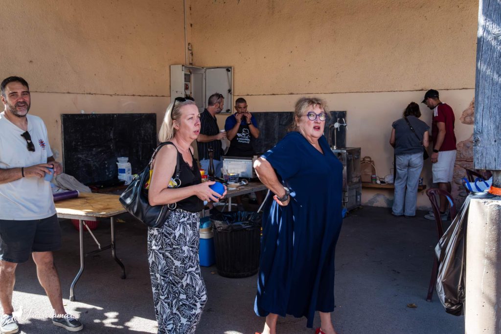 Convives qui arrivent sous le préau pendant que la plancha chauffe, repas du club de pétanque de Néfiach