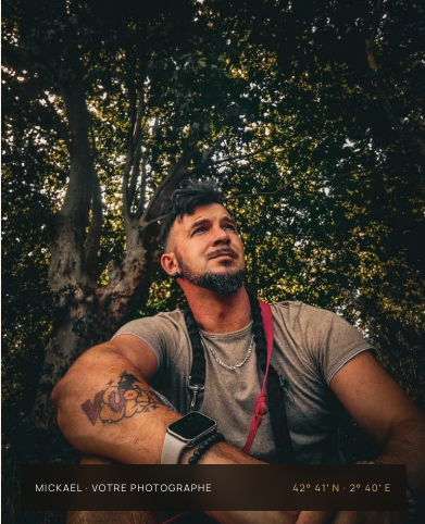 Mickael, photographe de Fievrelama, assis sous les arbres avec son appareil photo en bandoulière