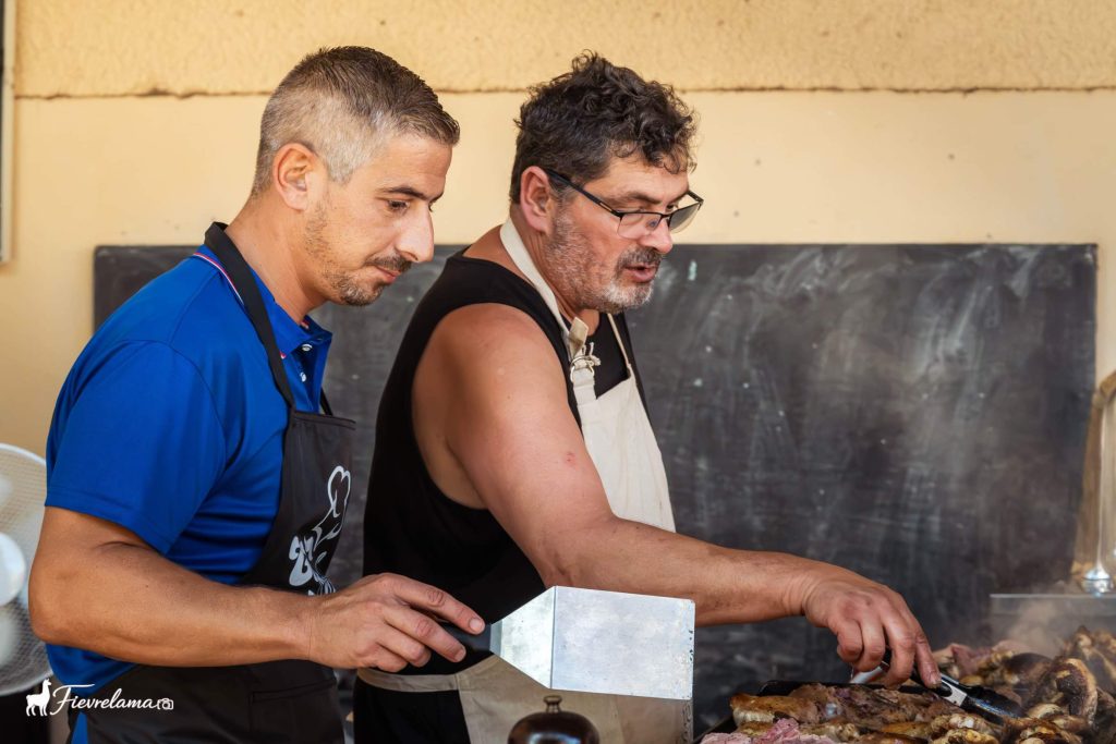 Deux bénévoles en tablier aux commandes de la plancha du repas de la Pétanque Néfiachoise