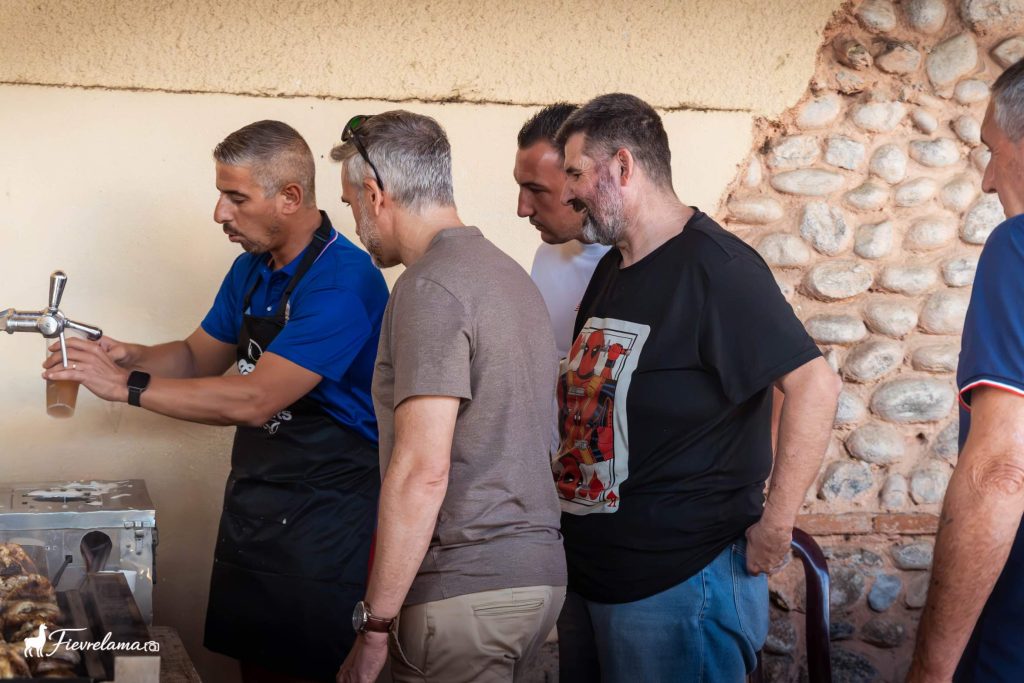 Bénévole qui sert une bière à la tireuse pendant le repas du club de pétanque